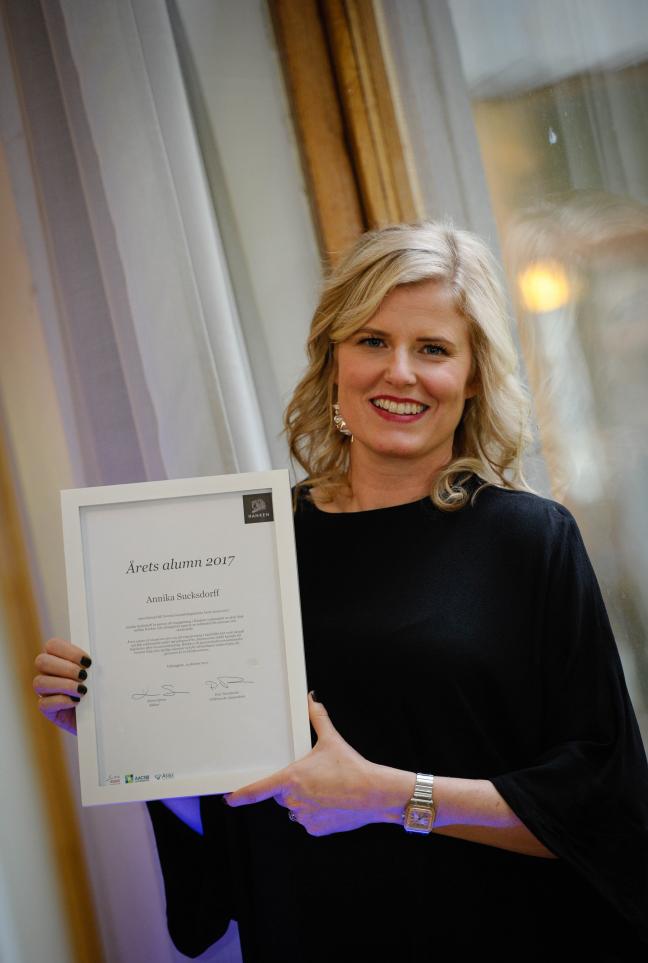 Picture of Alumnus of the Year, Annika Sucksdorff, holding her diploma. 