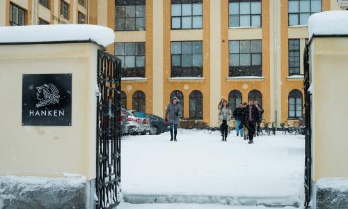 Yellow building with people on yard
