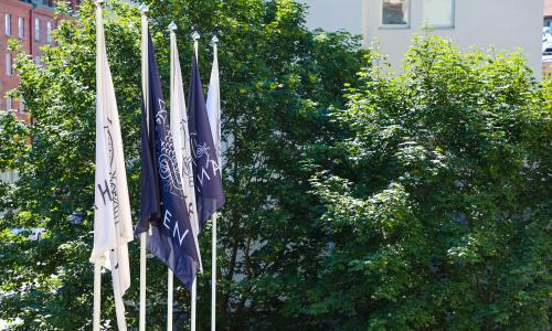 Hankens flaggor framför gröna träd