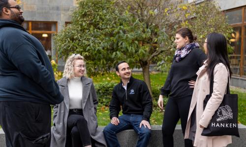 Five PhD students standing outside Hanken in Helsinki