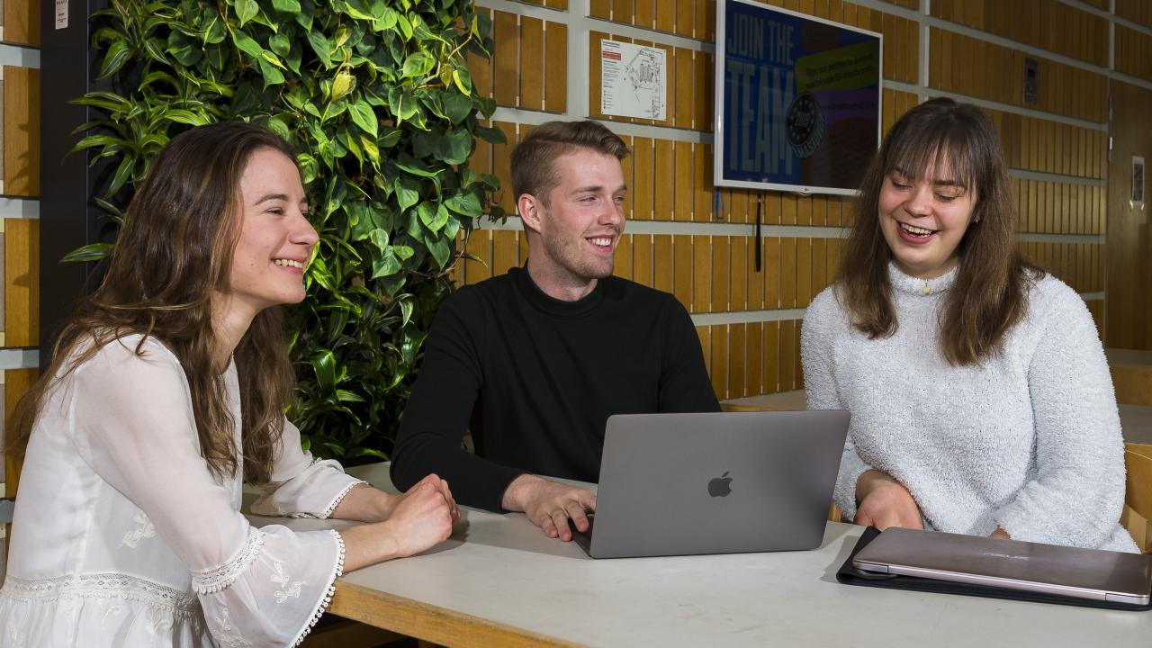 Studerande diskuterar i foajén