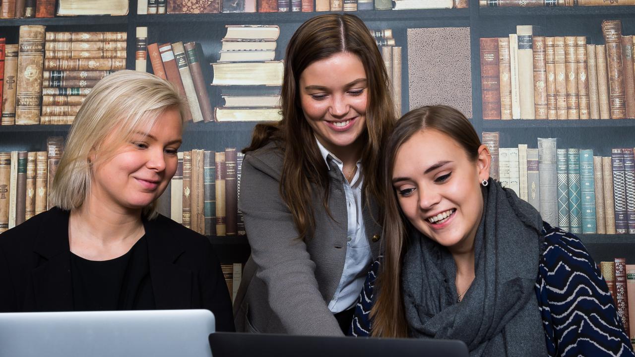 Tre kvinnor tittar tillsammans på en datorskärm