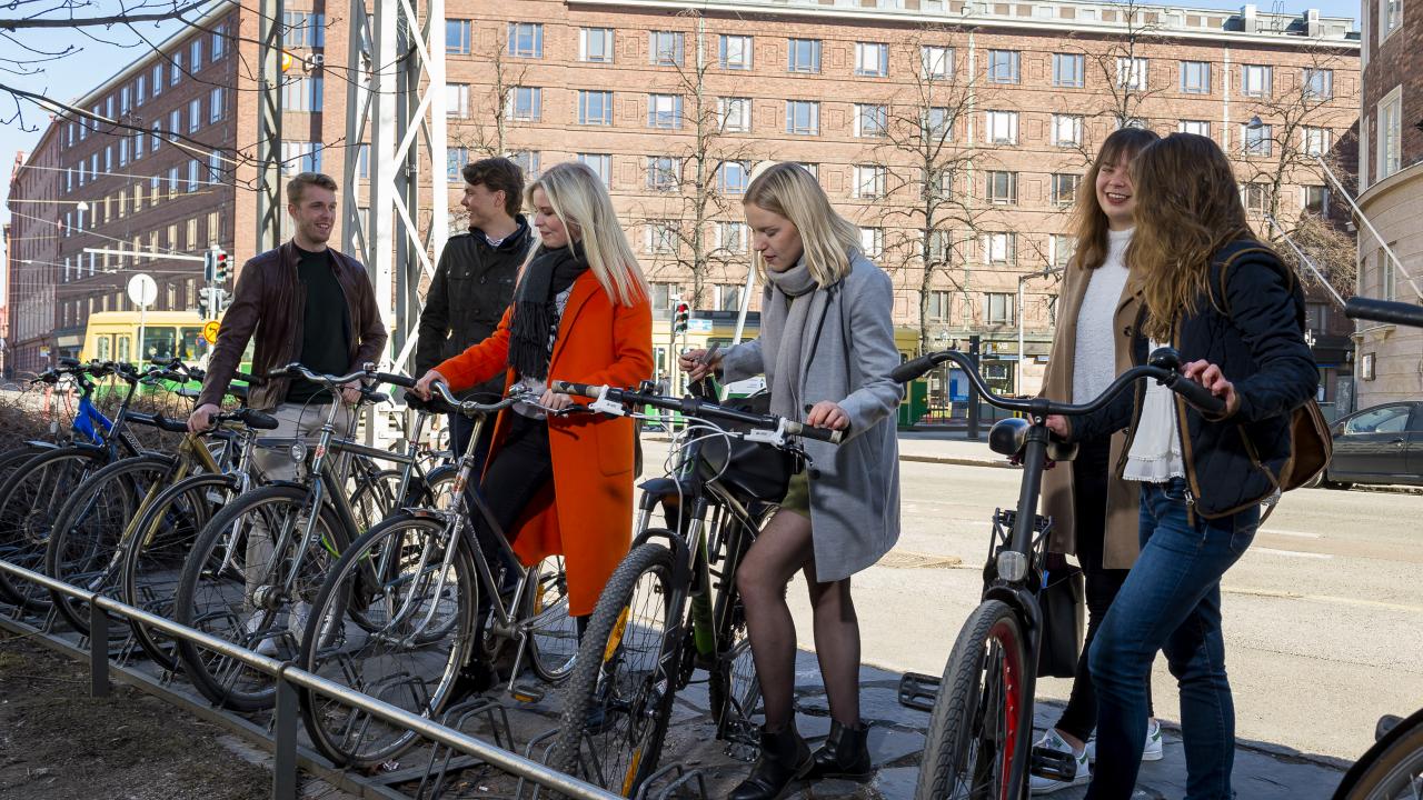 Six students at a stand for bicycles