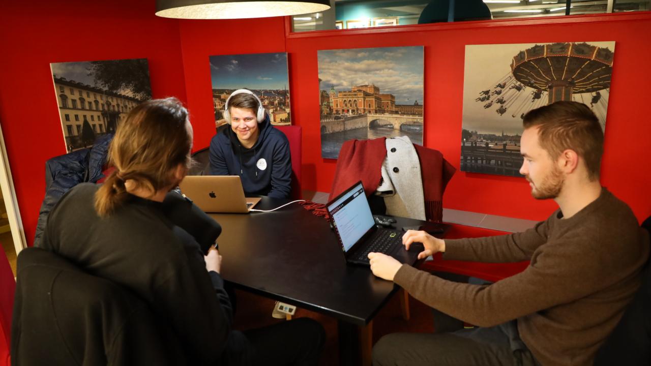 Tre studerande med laptops i Hanken Business Lab