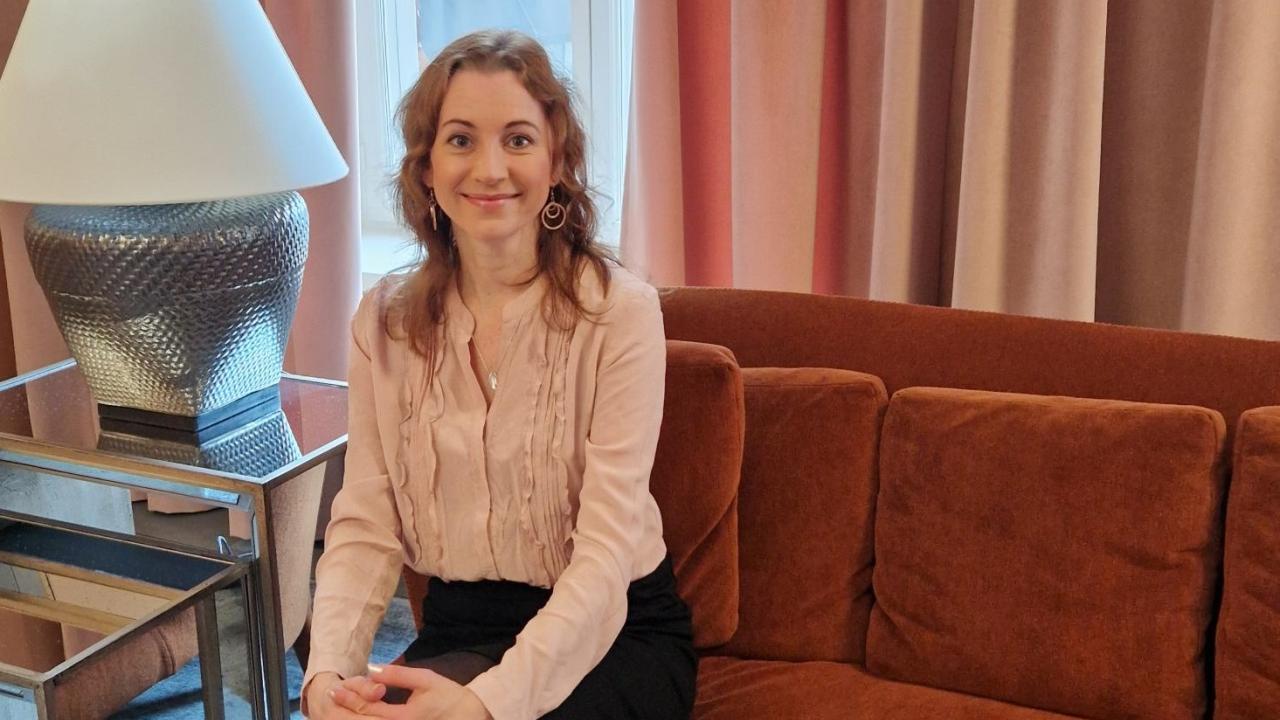 Joanna Kivi sitter på en soffa i Mandatums kontor.