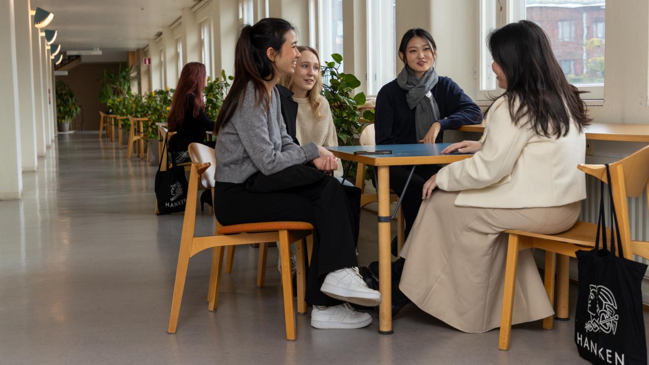 Studenter vid ett bord i korridor