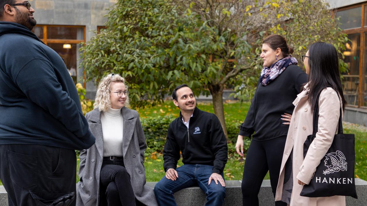 Five PhD students standing outside Hanken in Helsinki