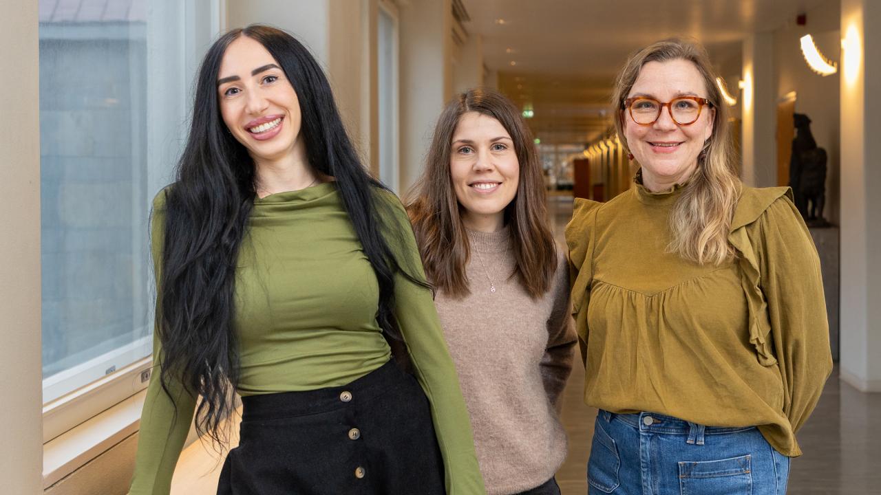 Researchers Leyla Yacine, Emma Nordbäck and Hertta Vuorenmaa stand beside each other in the Hanken corridor