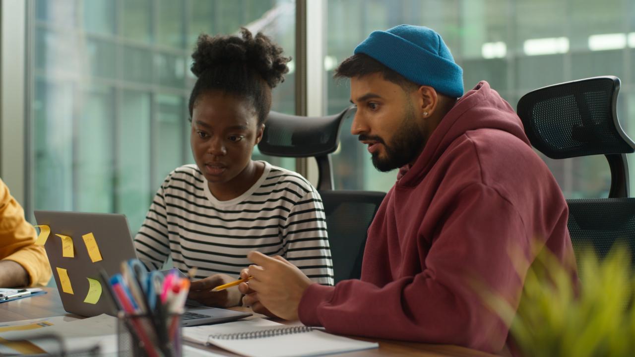 Young entrepreneurs causally dressed sitting by a computer.
