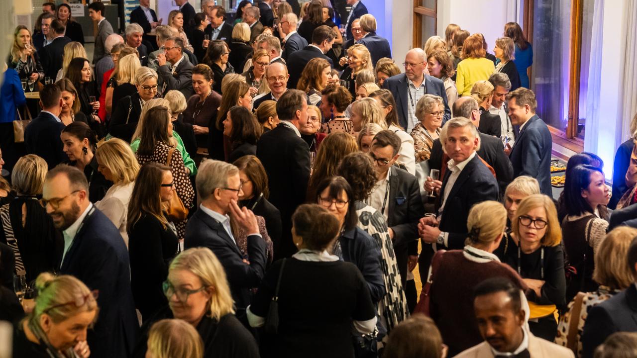 Hanken alumni mingling at an event in the Hanken foyer.