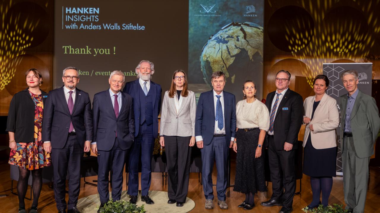 The speakers at the Hanken Insights event standing together on the stage in the Hanken Assembly Hall