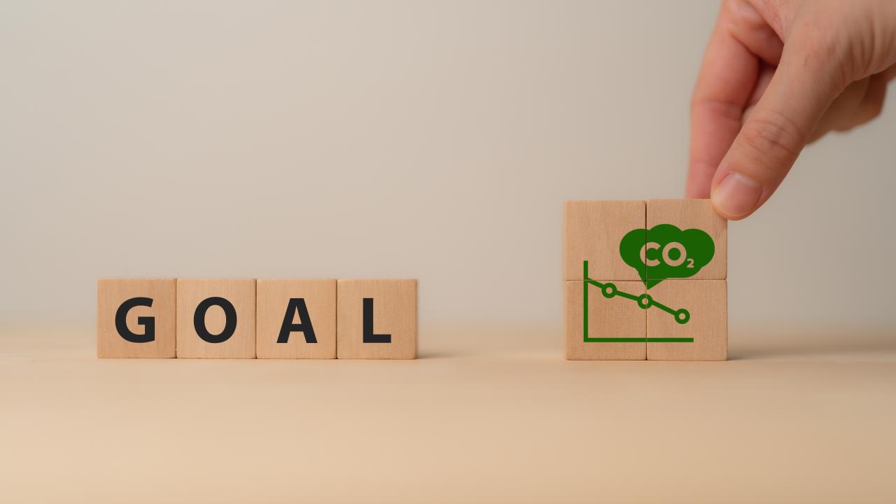 Wooden letter blocks with the word "GOAL" and decreasing CO2 emission graph.