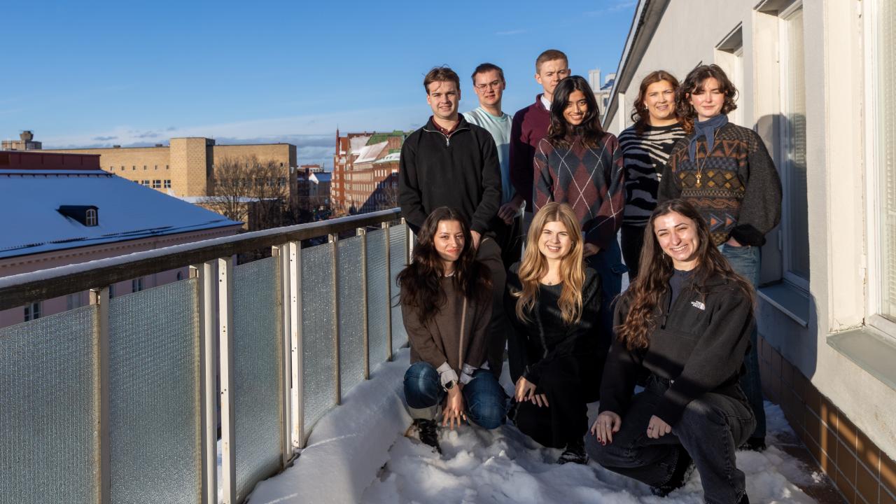 GSM programme students standing on a Hanken balcony in the sun.