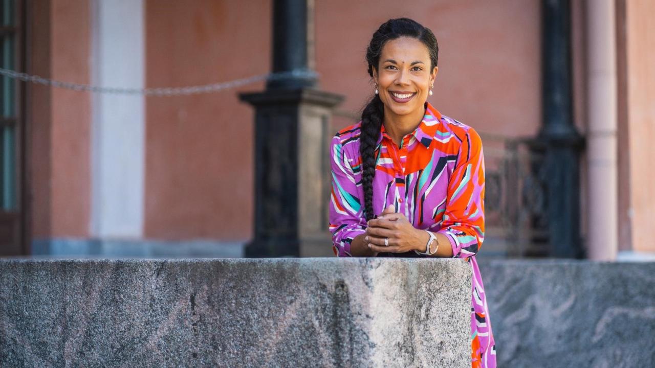 Professor of Practice Shadia Rask standing on a staircase facing the camera.