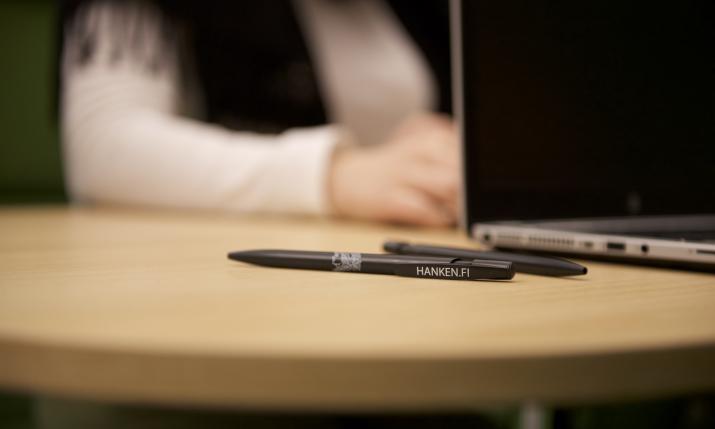 En bild med laptop och två stycken Hanken pennor