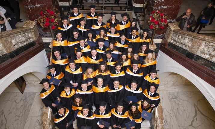 Group picture of QTEM graduates dressed in graduation gowns.
