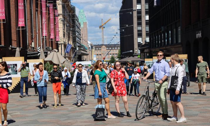 People standing in the middle of a walking street in Helsinki. 