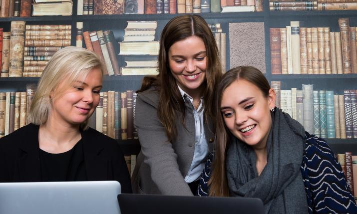 Tre kvinnor tittar tillsammans på en datorskärm