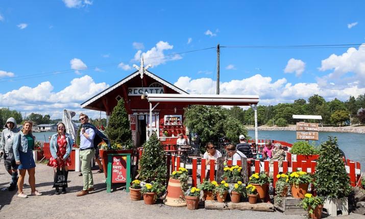 A group of people standing in front of Cafe Regatta in helsinki in the summer