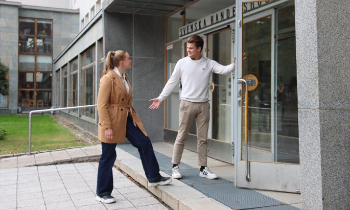 Student opening the door for another student