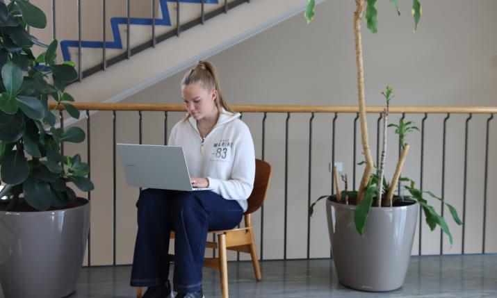 A student is sitting with a laptop