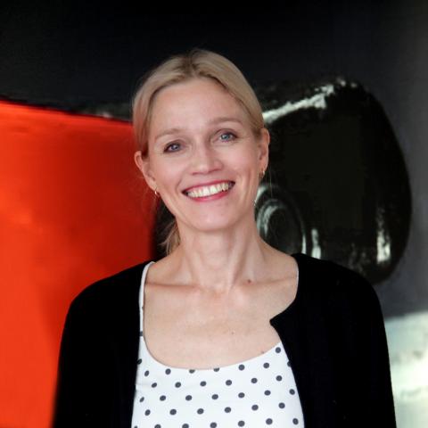 En kvinna, Päivi Koivisto, ser leende in i kameran.