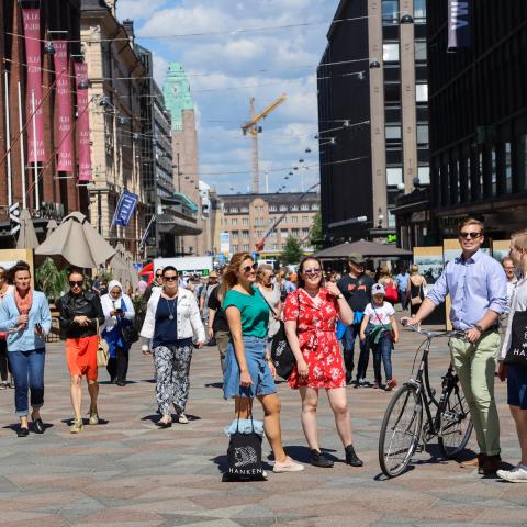 People standing in the middle of a walking street in Helsinki. 