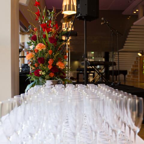 Tomma glas och blommor i vas, i väntan på fest