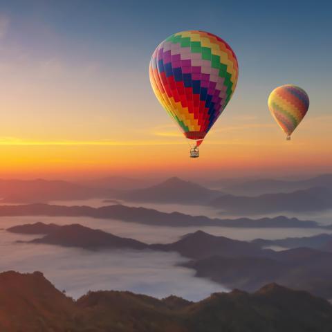 Luftballonger uppe i luften i solnedgången