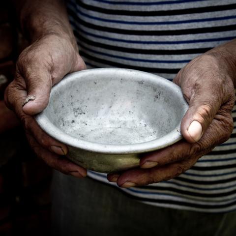 Händer som sträcker fram en tom skål
