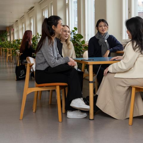 Studenter vid ett bord i korridor