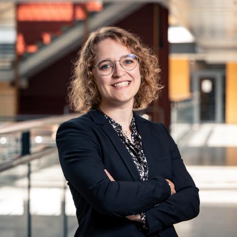 Alexandra Dahlberg standing in a corridor, smiling at the camera