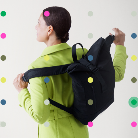 A woman putting on her backpack and walking away from the camera