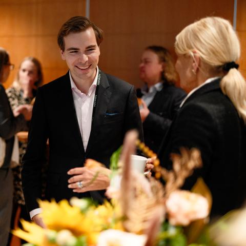 Hanken alumni smiling and talking at an event.