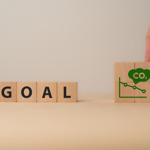 Wooden letter blocks with the word "GOAL" and decreasing CO2 emission graph.