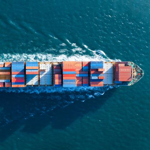 A ship with containers pictured from above.