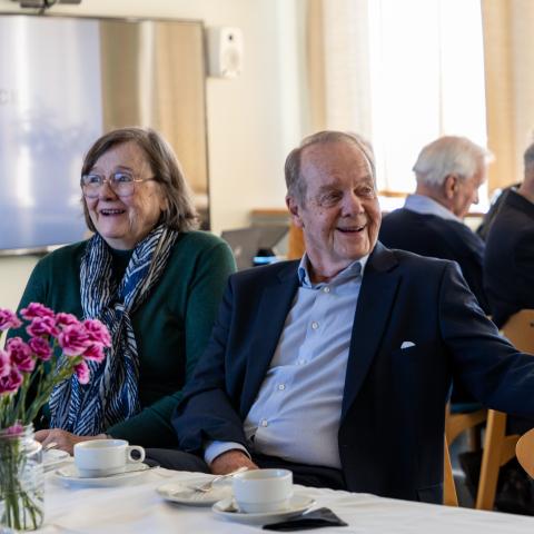 People drinking coffee and laughing together at a alumni reunion event at Hanken.