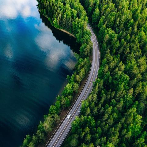 A view of a lake, a forest and a road in Finland from above.