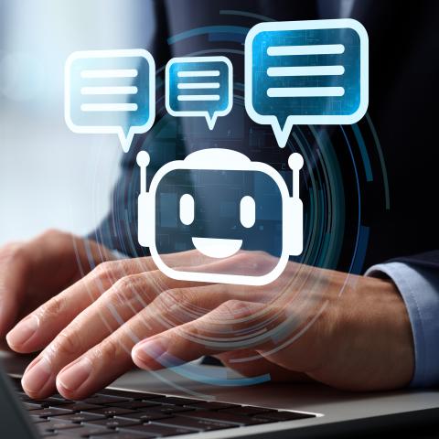 A person writing on a computer while an image of a chatbot appears.